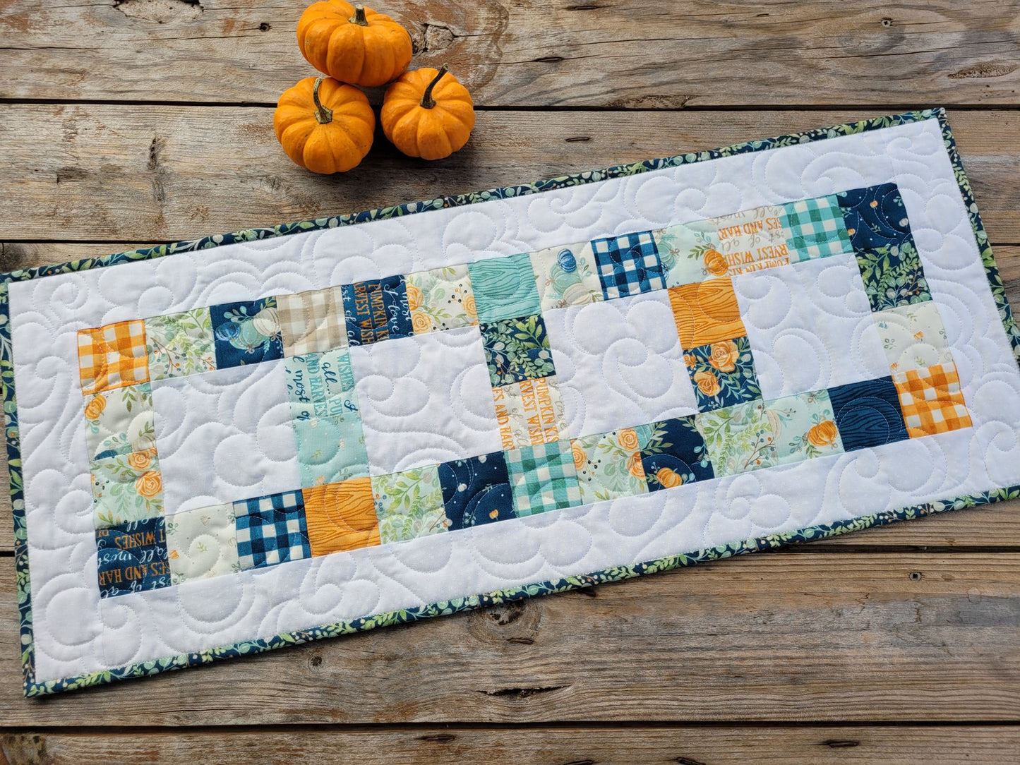 Quilted table runner with harvest pumpkins