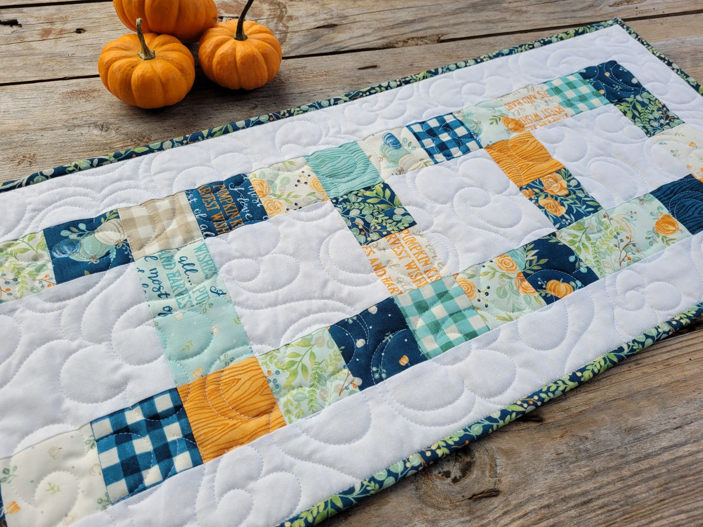 Quilted table runner with harvest pumpkins