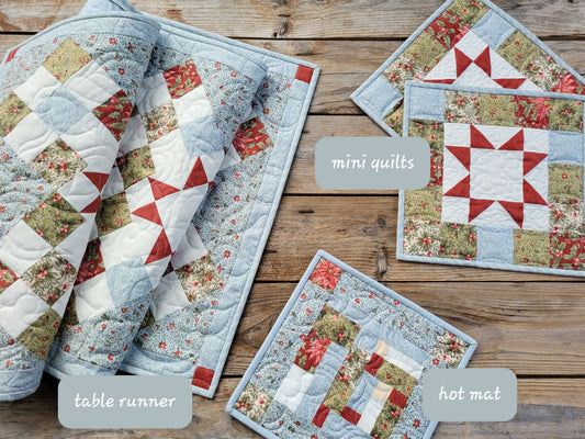 Showing quilted table runner with two mini quilts and one hot mat in coordinating christmas fabrics.