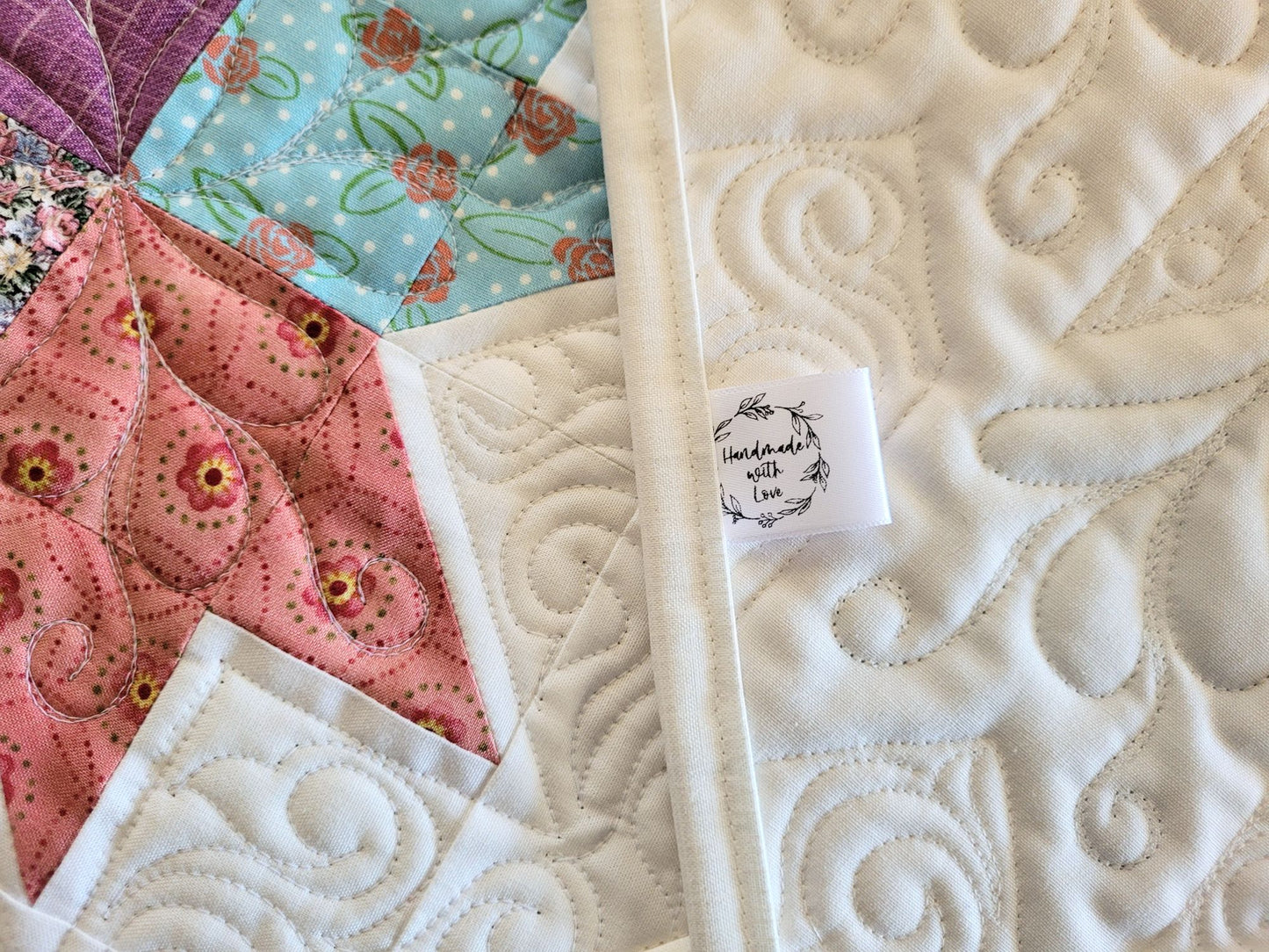 Spring tulip table runner in pastel patchwork on white background. Handmade label, shown in close up.