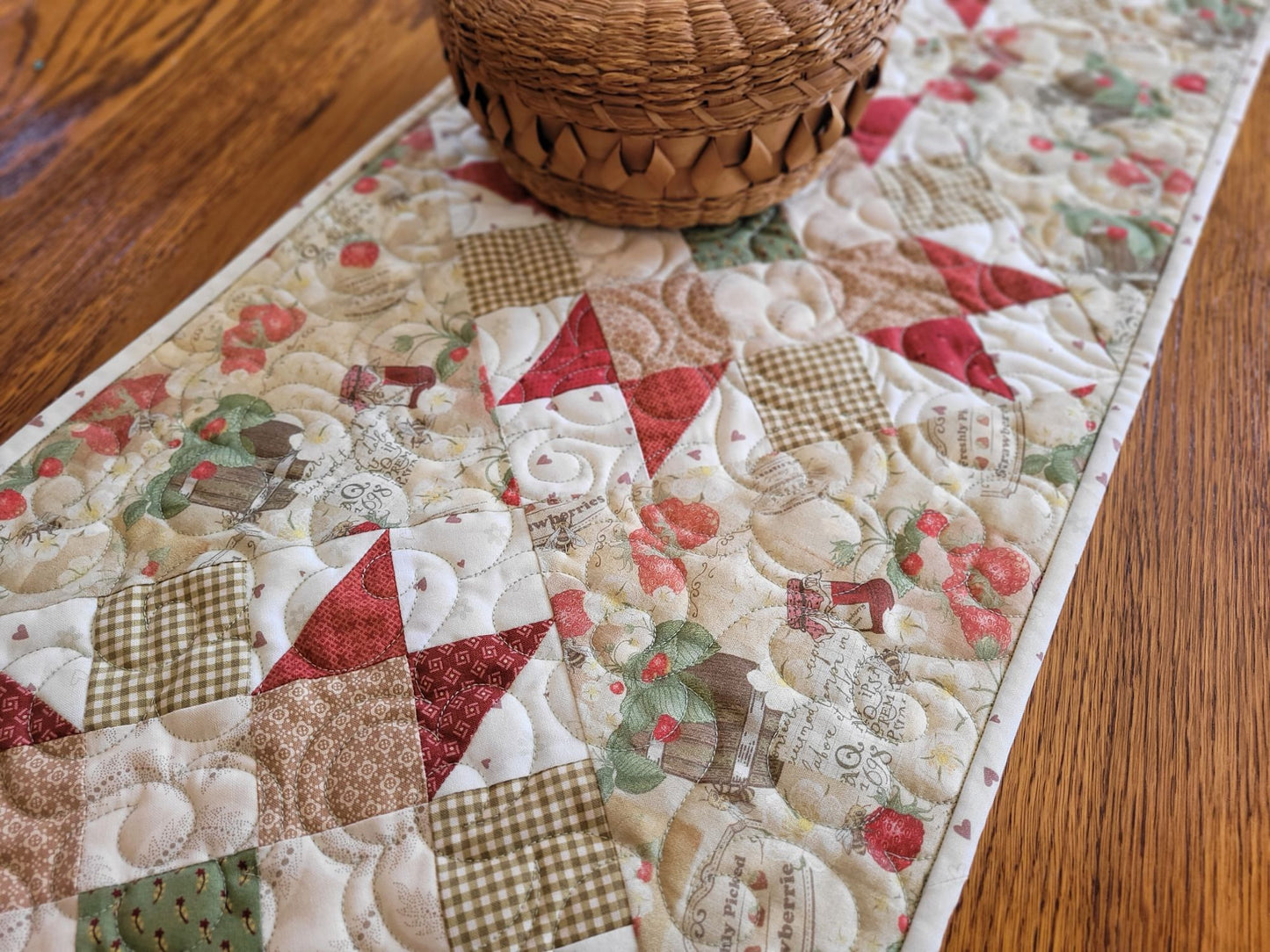 strawberry quilted table runner on table with small wicker basket