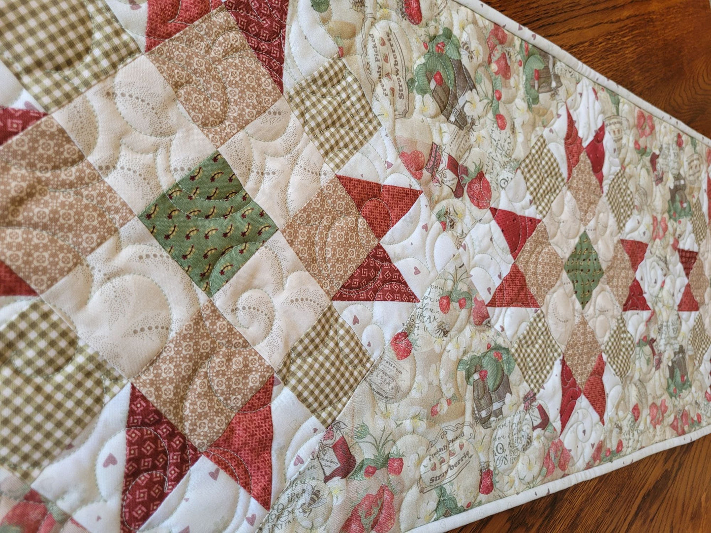 strawberry quilted table runner shown on angle view