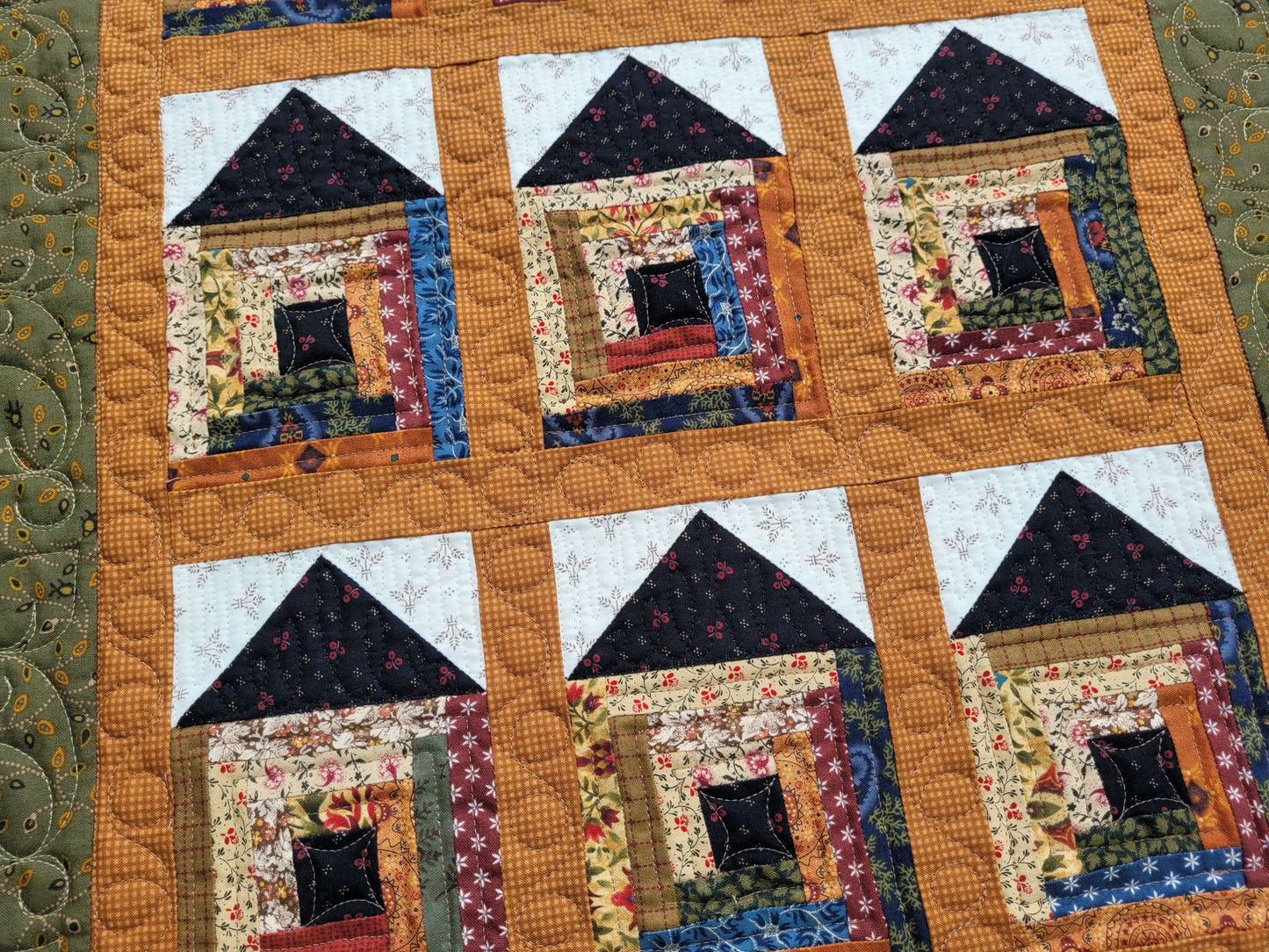 Quilt with house-shaped blocks on a textured background