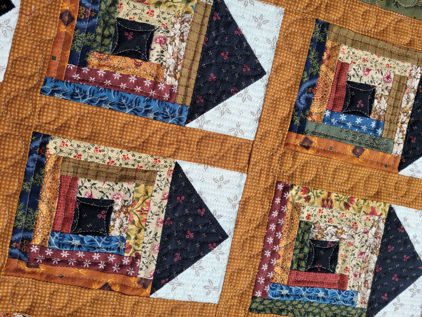 Quilt with rustic patchwork design featuring various colours and patterns.