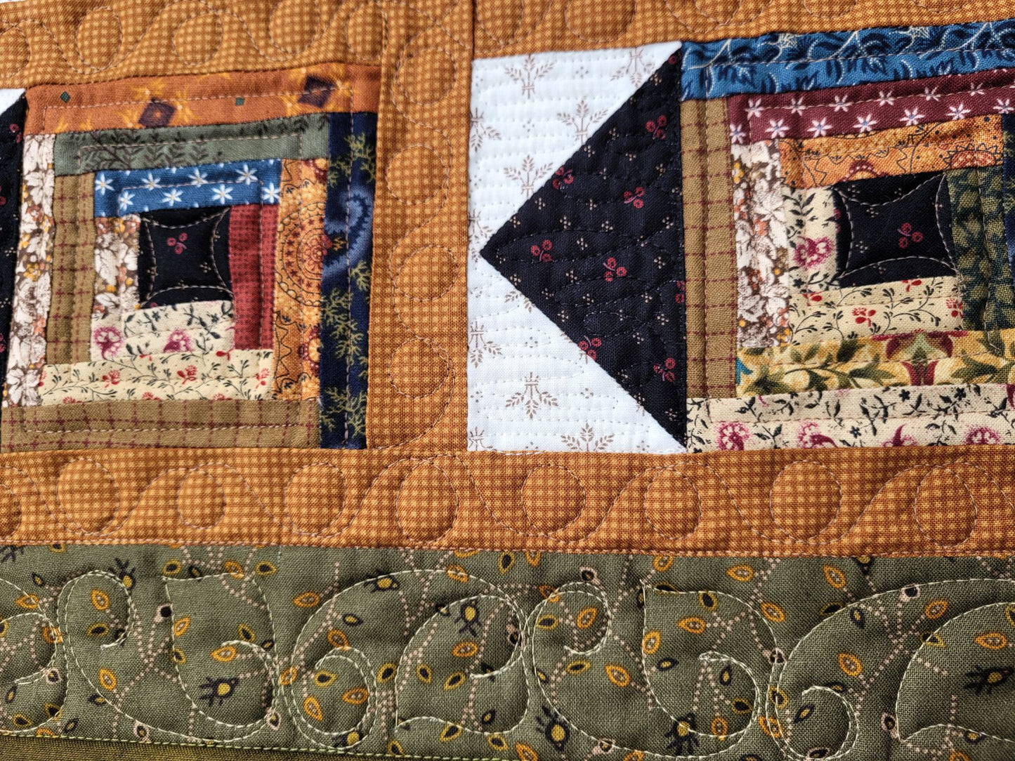 Close-up of a rustic patchwork quilt with various fabrics and patterns.