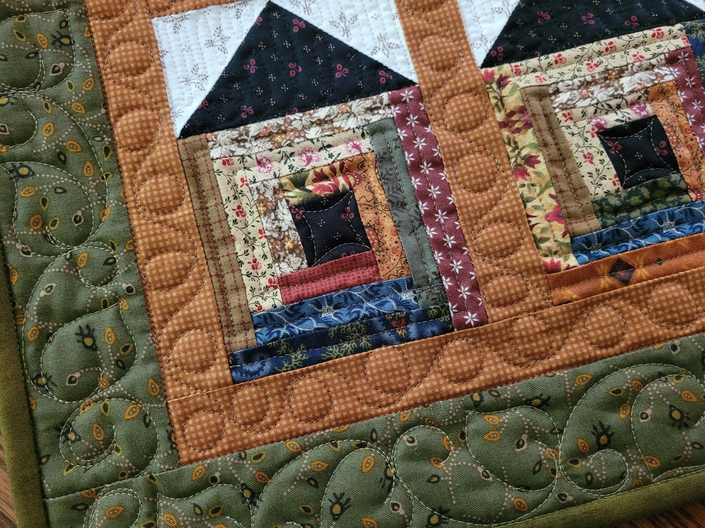 Quilted fabric with a house design and green border