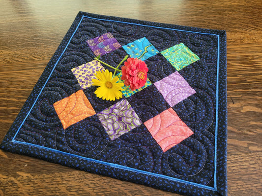 Patchwork quilt with colorful squares and flowers on a wooden surface