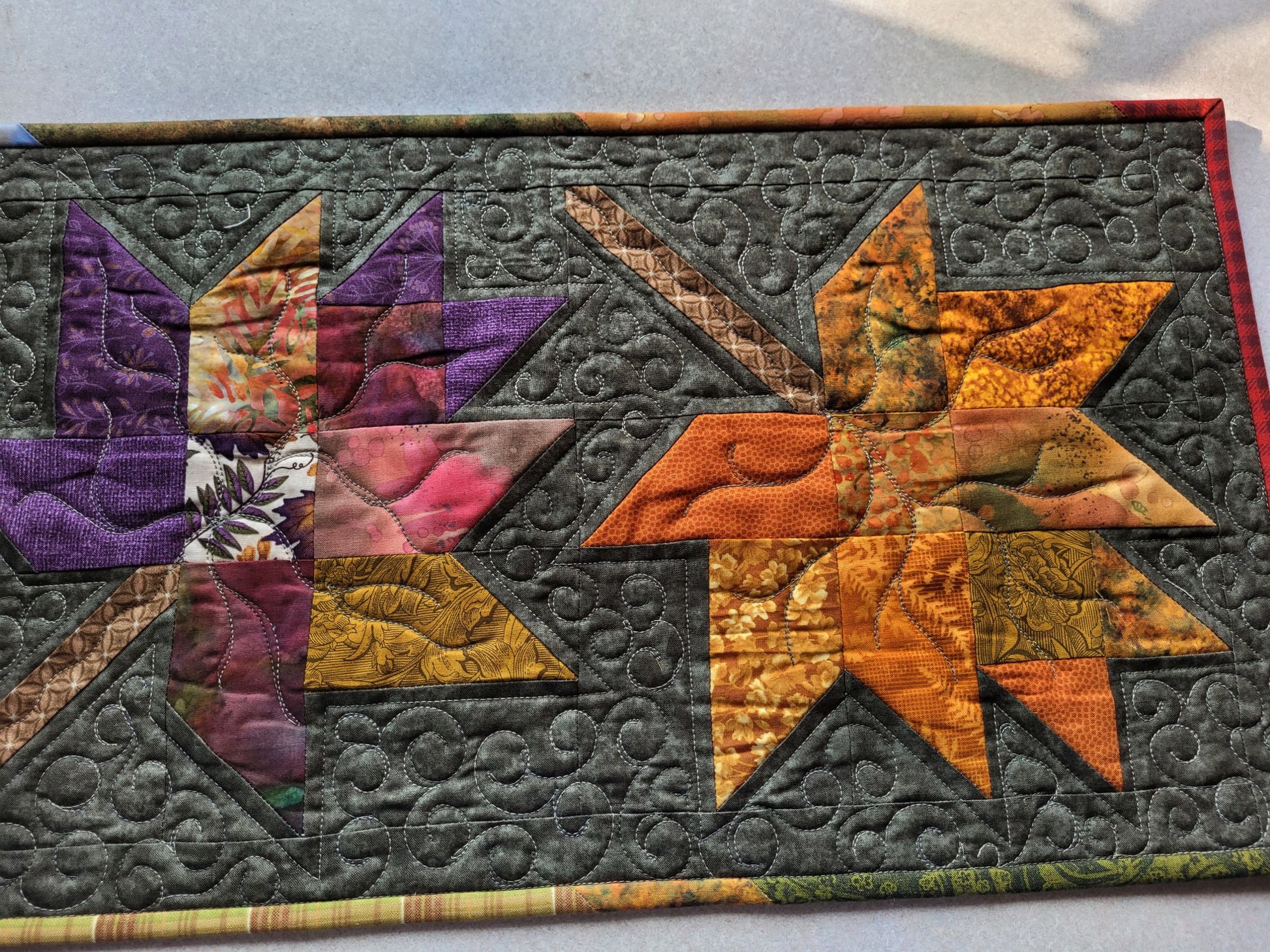 Close up of stitching detail on quilted autumn leaf table runner.