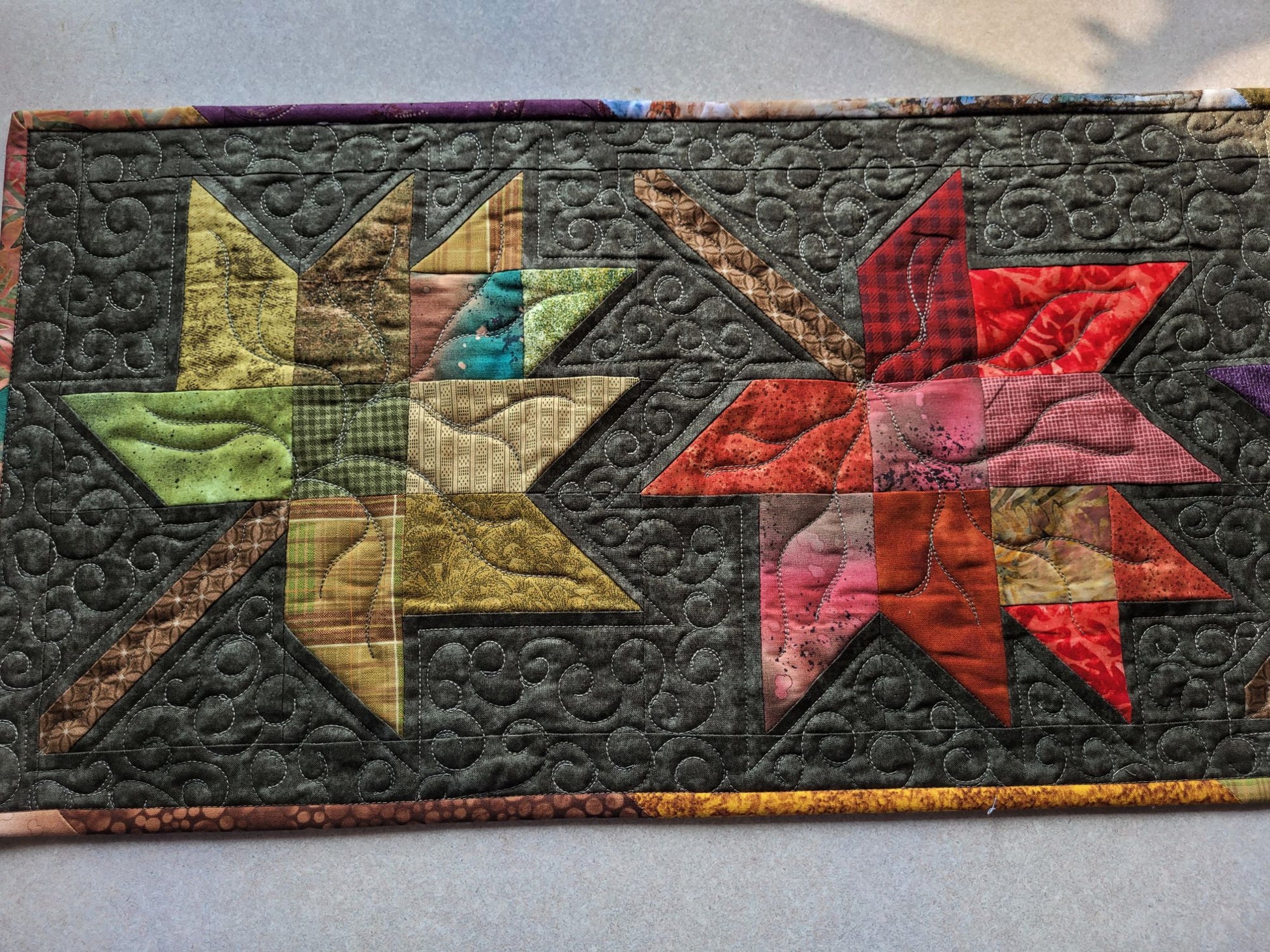 Close up showing stitching detail on quilted leaf table runner.