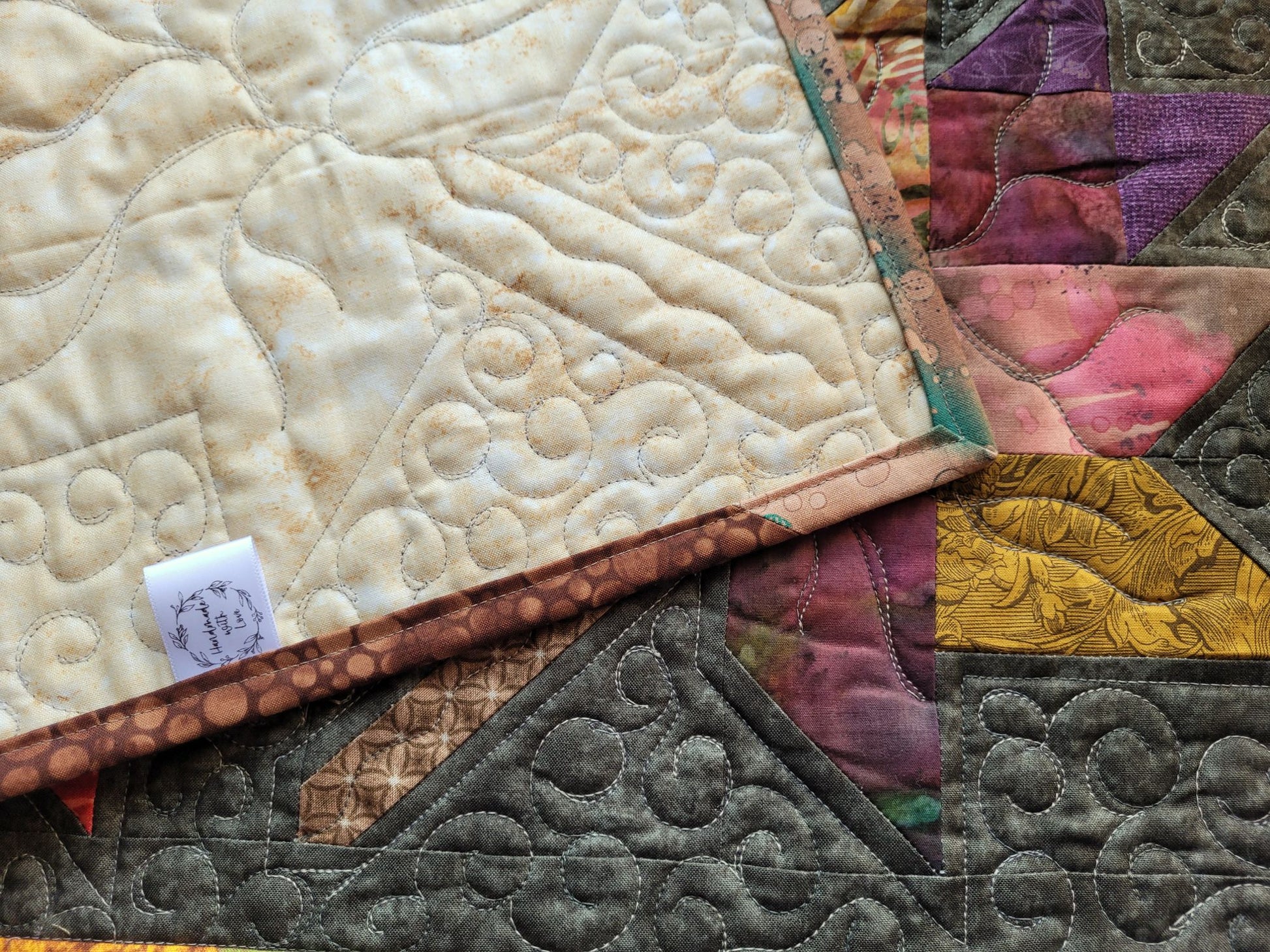 Showing the back of the quilted table runner with the handmade label.