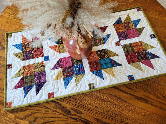 Colourful quilt with star patterns on a wooden surface