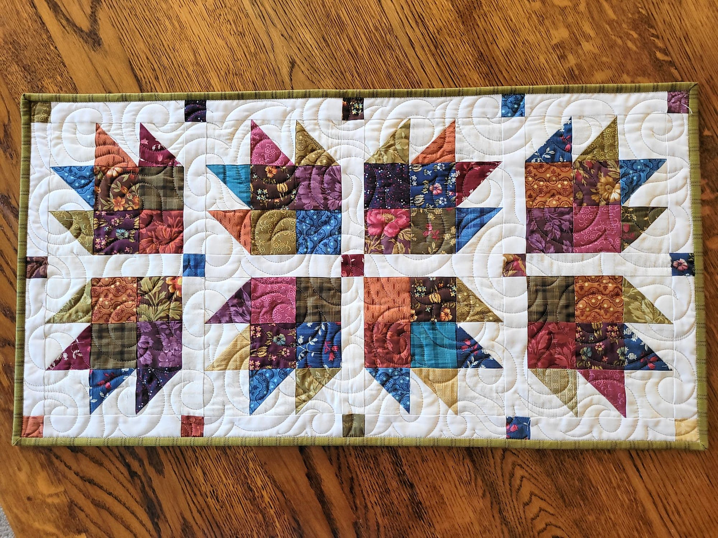 Colourful quilt with star pattern on a wooden surface