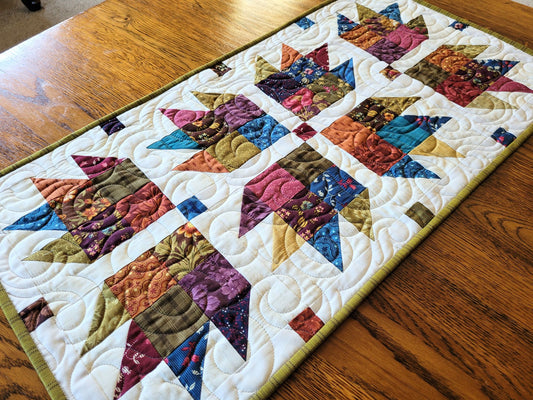 Colourful quilted table runner on a wooden surface