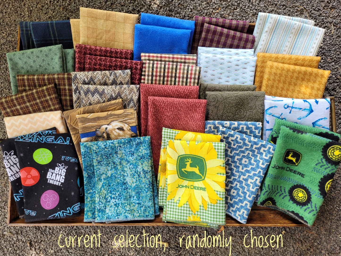 Collection of various patterned fabric hankies in a box on a textured surface.