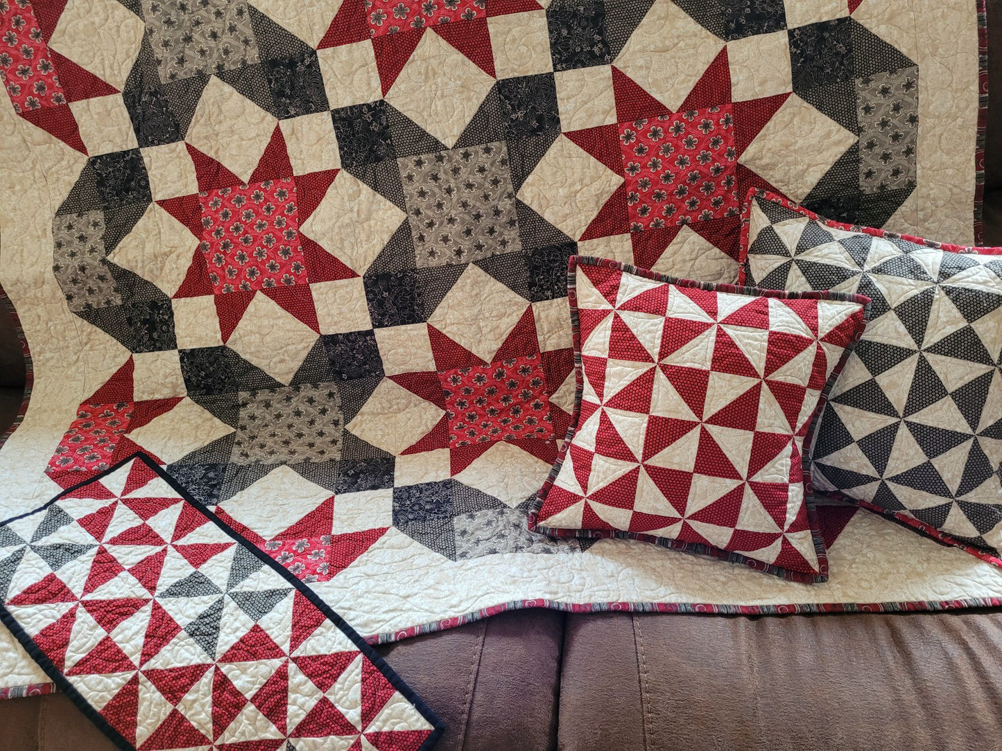 Quilt with geometric star pattern and matching pillows on a couch