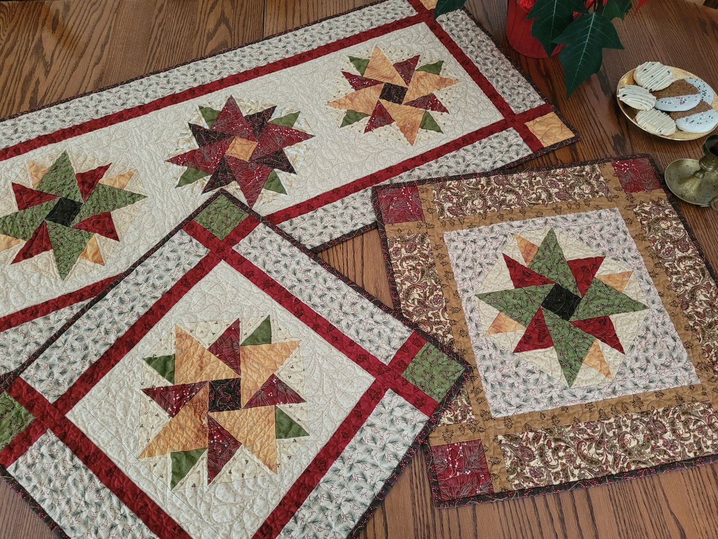 The Heritage Star Collection of Christmas quilts, one large table runner and two smaller table toppers, on a dining table