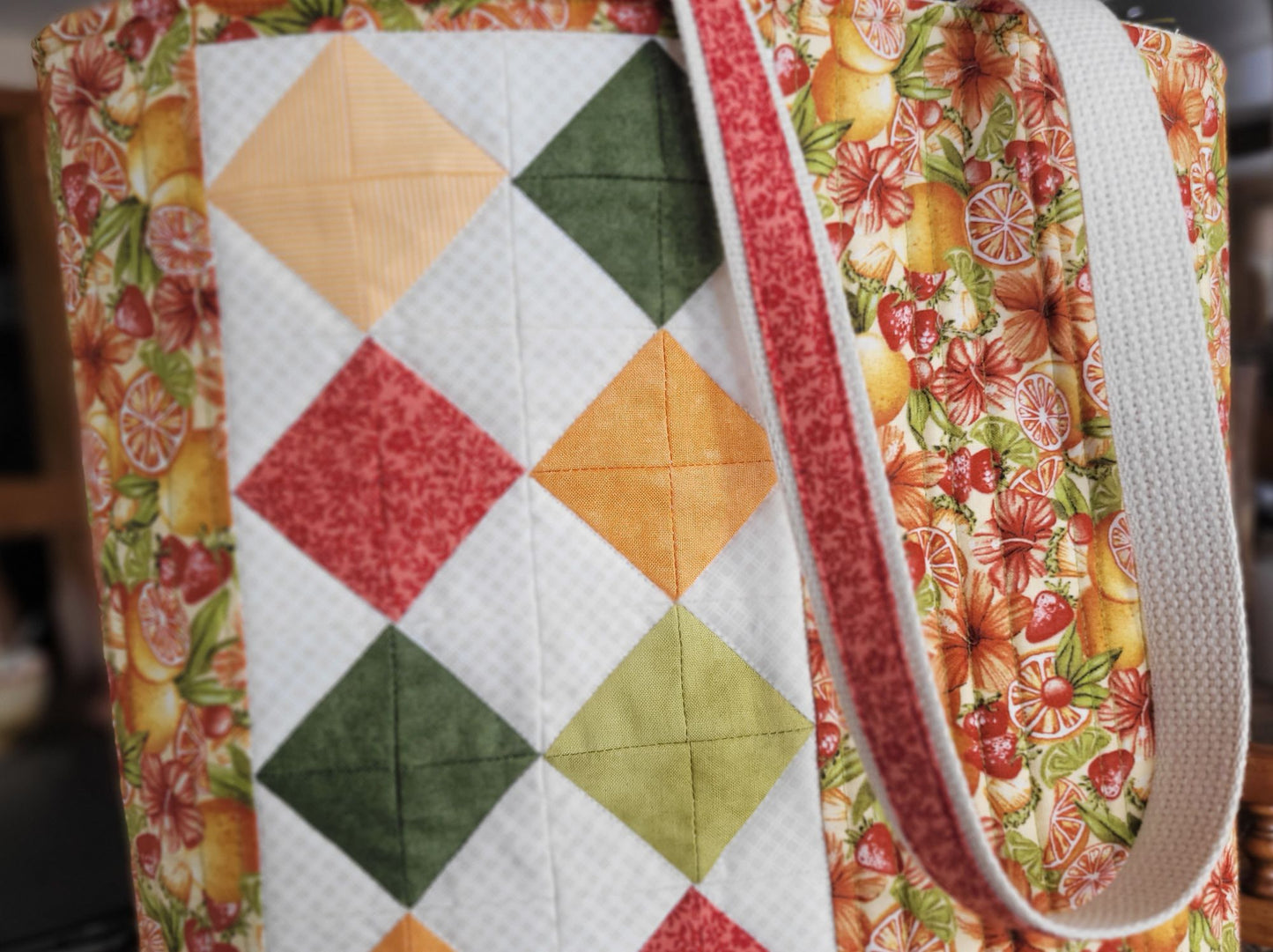 Quilted tote bag with diamond patchwork and colourful floral and fruit fabric.