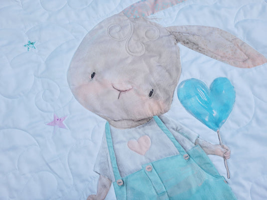 Close up of baby quilt showing cute bunny stitching detail.