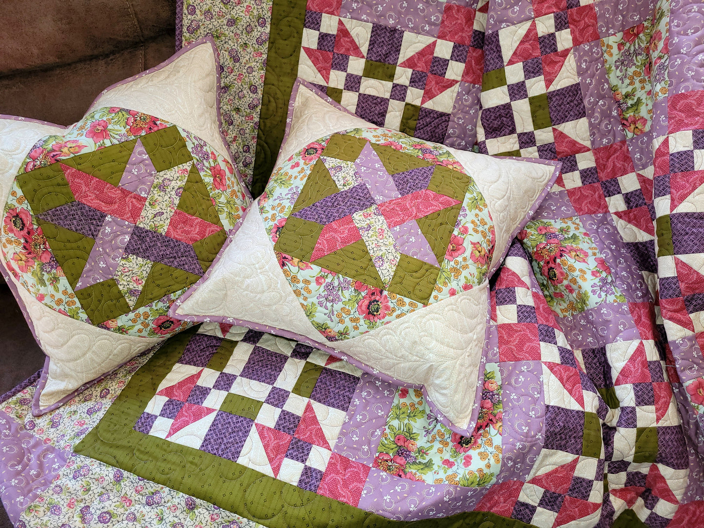 Patchwork Throw quilt with two matching pillows draped on a brown sofa.