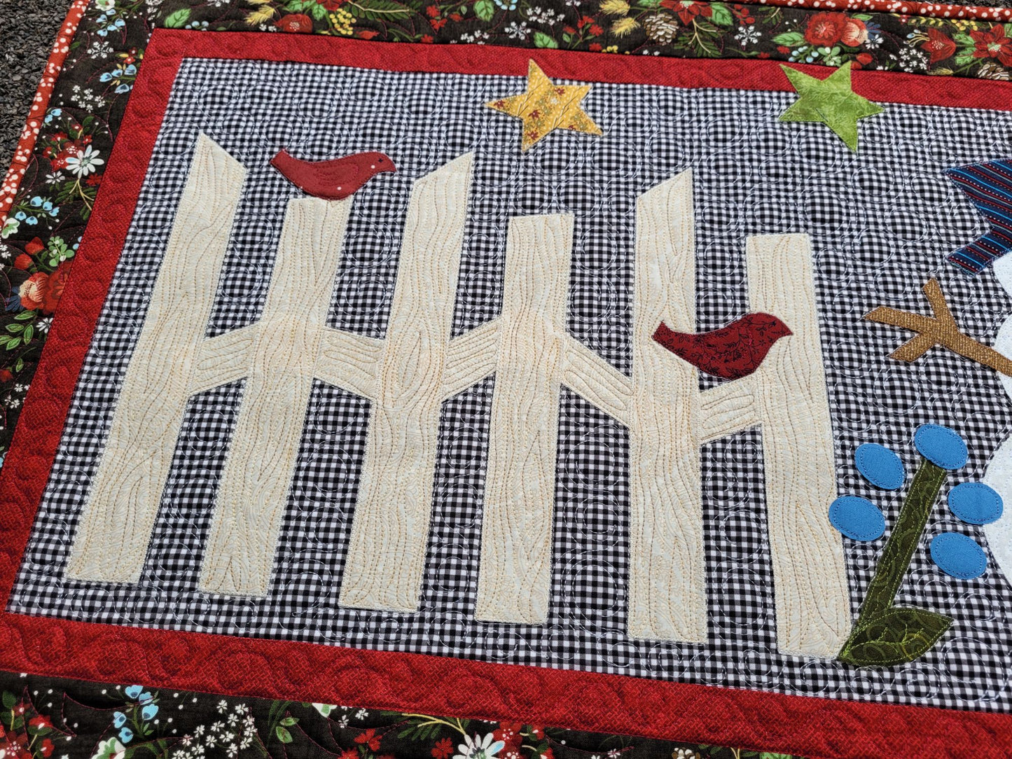 Showing rail fence detail with wood grain stitching and red birds sitting on it.
