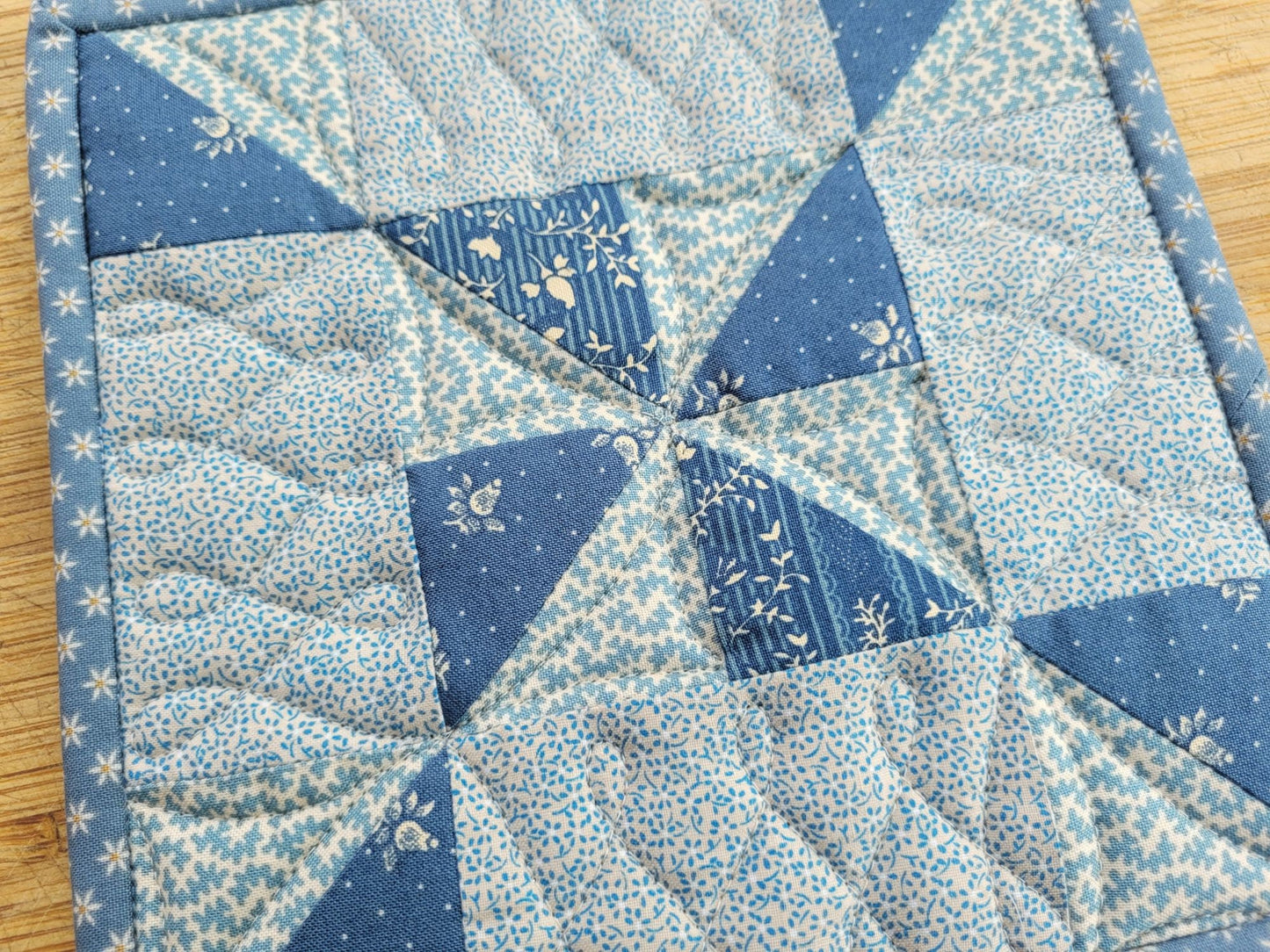 quilted hot mat in steel blue fabric with pinwheel patchwork design