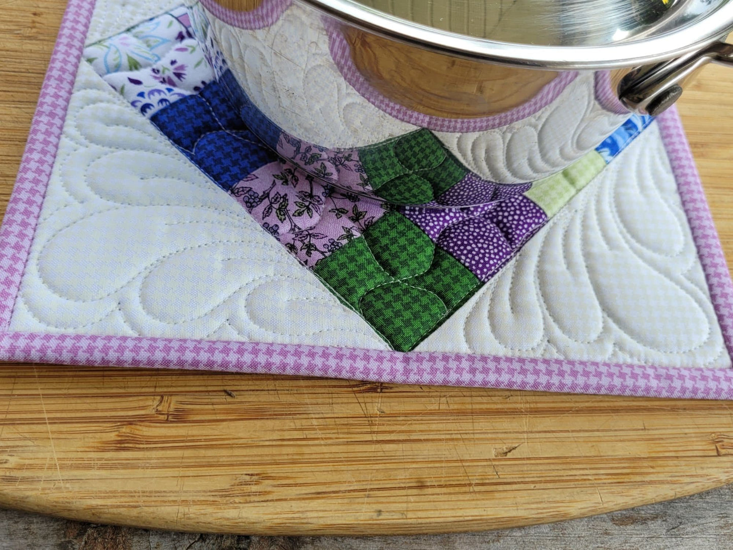 purple floral patchwork potholder under a small size saucepan
