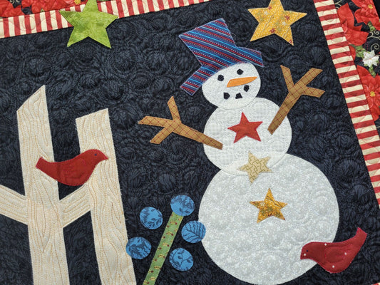 handcut appliqué snowman scene with stars, red birds and a fence on a black background