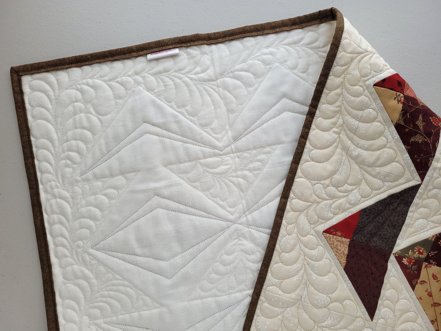 table runner showing feather quilting and backing