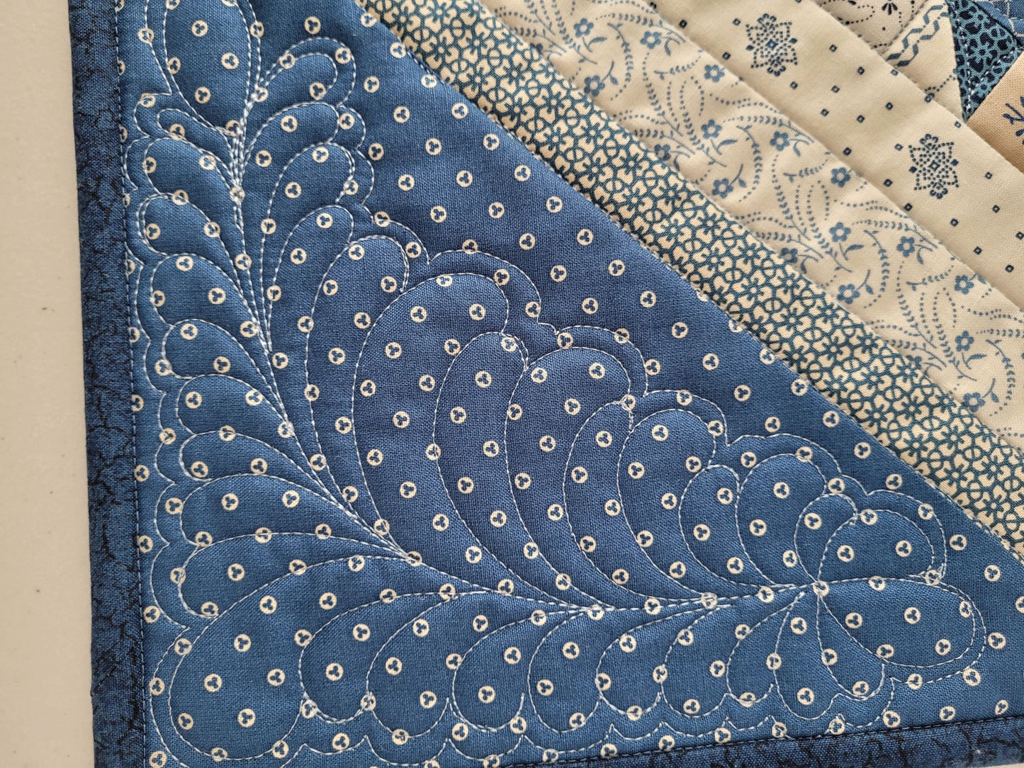 feather quilting detail on bear paw quilt