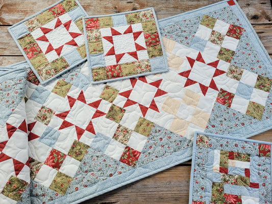 Christmas table runner with two mini quilts and a hot mat in coordinating ice blue poinsettia fabric.
