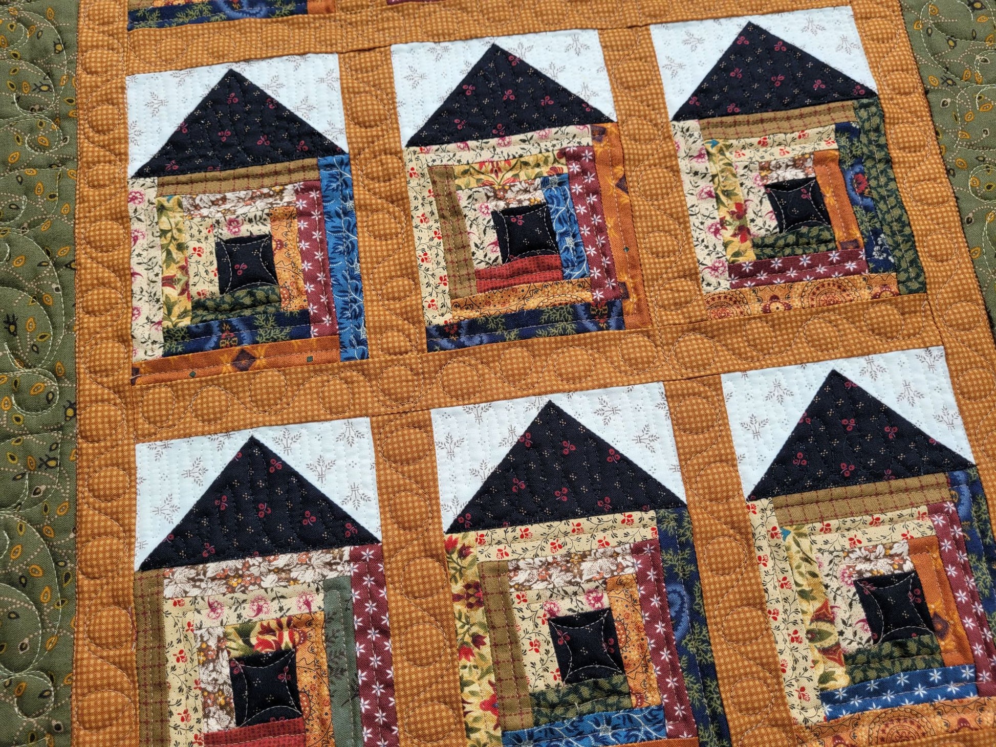 Quilt with house-shaped blocks on a textured background