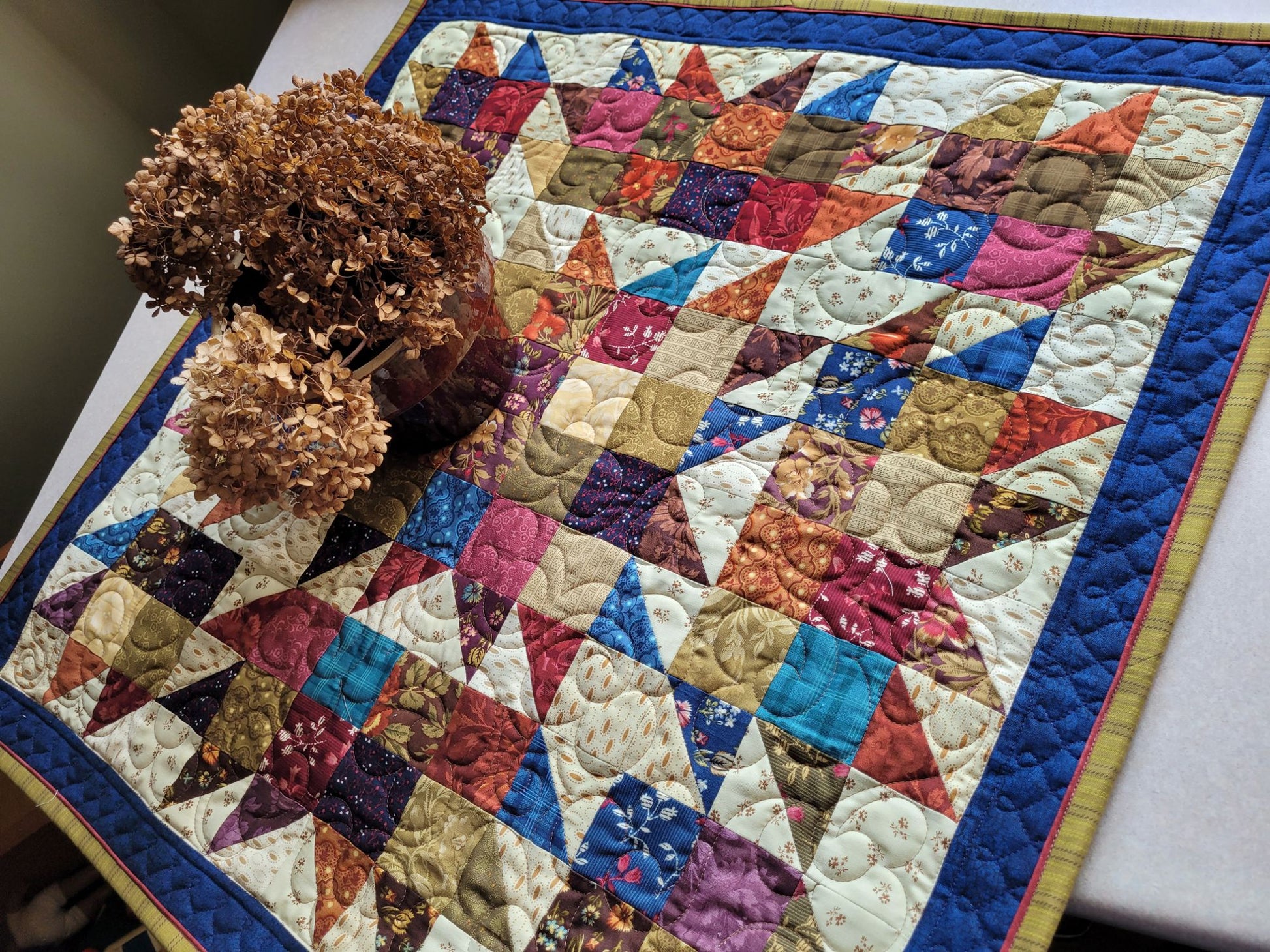 Colourful quilt with geometric pattern on a table