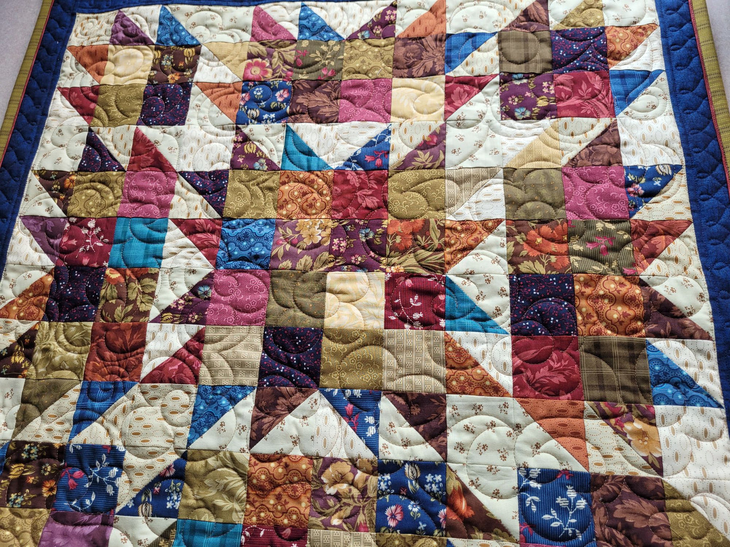 Quilt with a patchwork design featuring various colours and patterns.