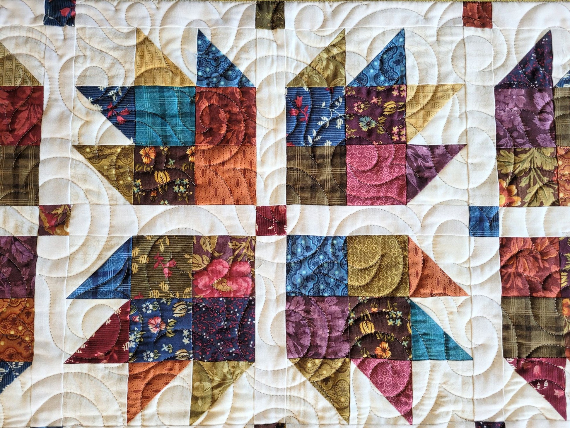 Quilt with colourful geometric pattern on a white background