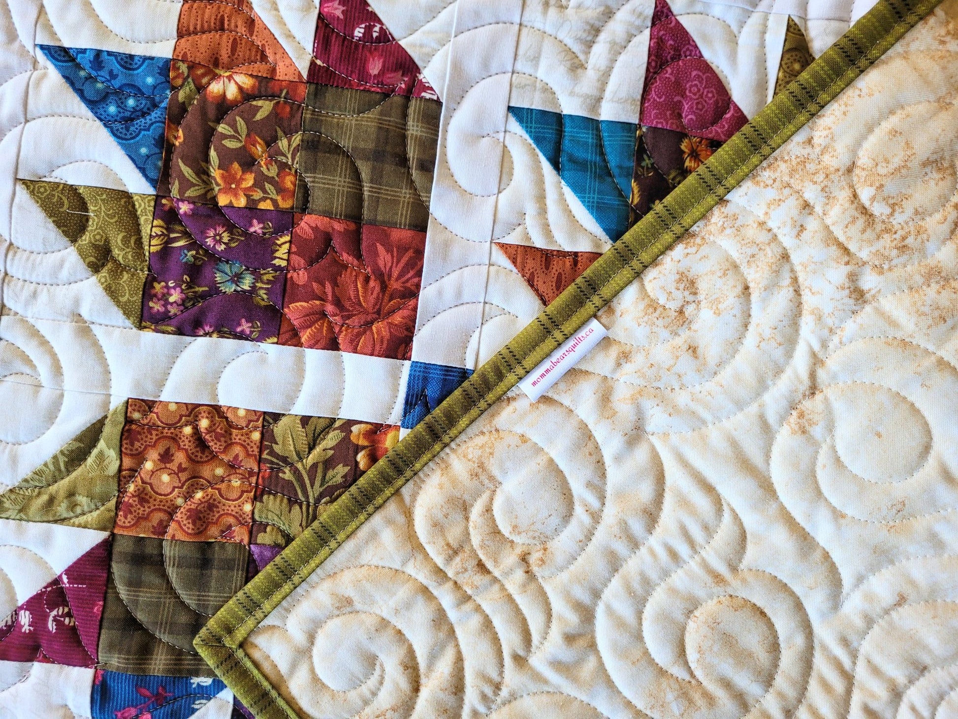 Quilt with colourful fabric squares folded to show backing.