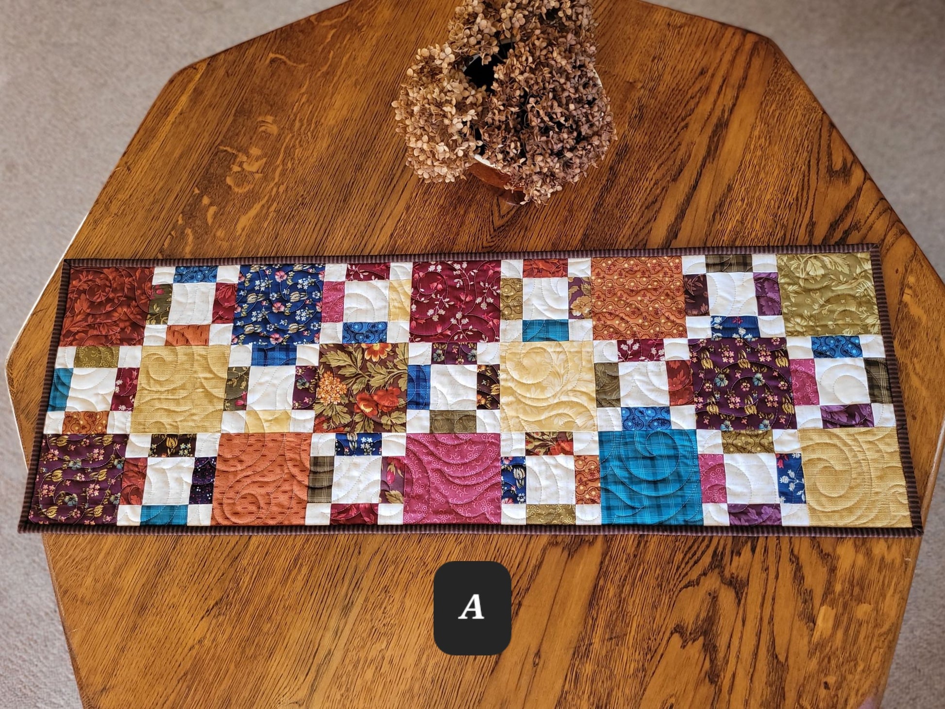 Colorful patchwork table runner on a wooden table
