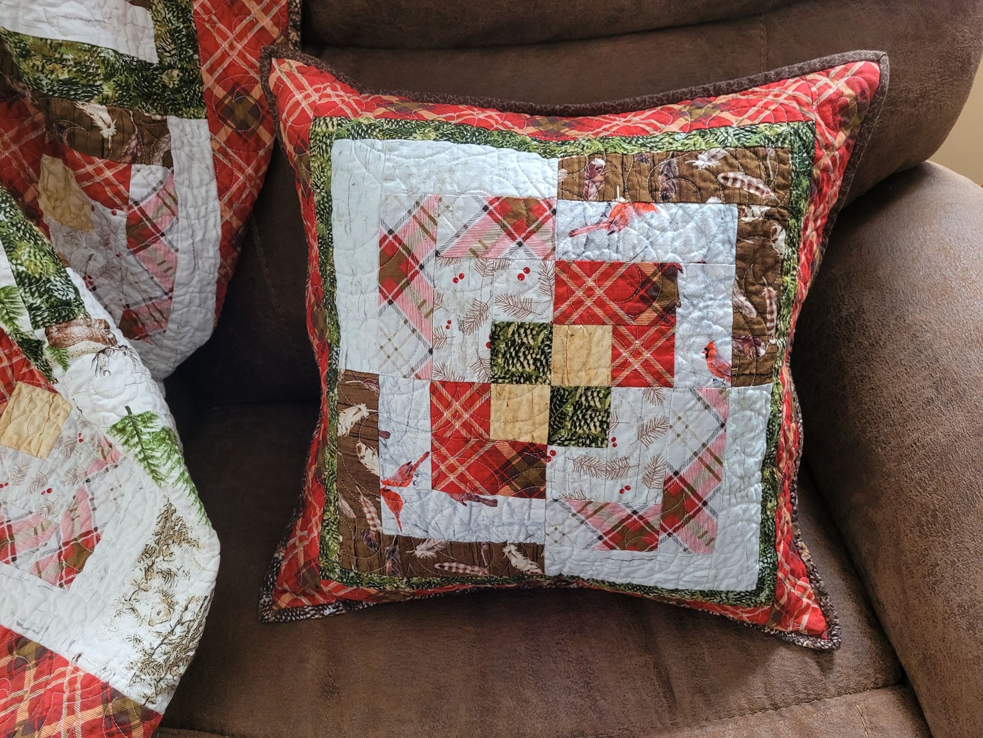 Quilted pillow with patchwork design on a brown couch
