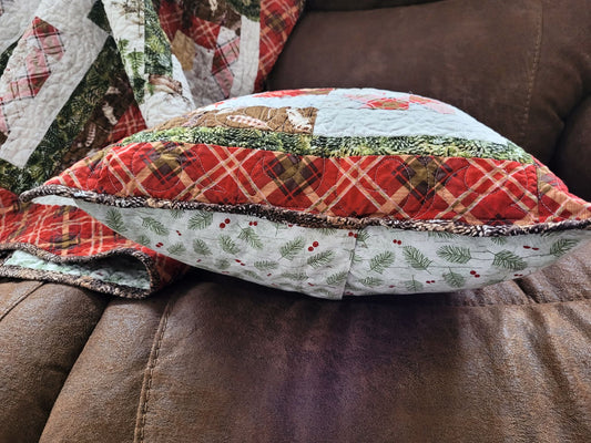 Quilted pillow with plaid pattern on a brown sofa, side view