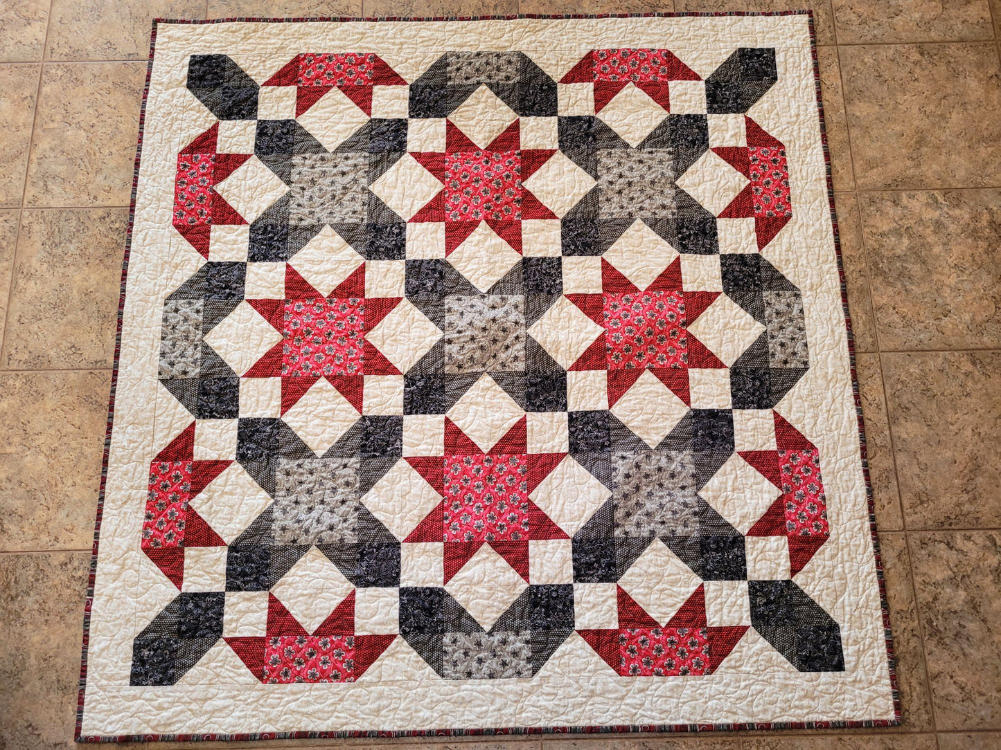 Quilt with star pattern on a tiled floor