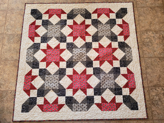 Quilt with star pattern on a tiled floor