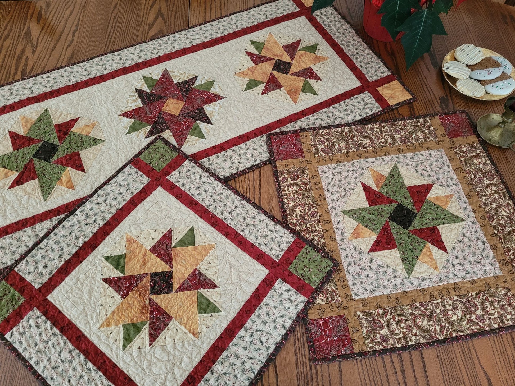 The Heritage Star Collection of Christmas quilts, one large table runner and two smaller table toppers, on a dining table