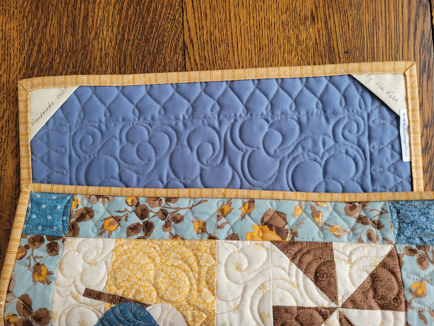 Showing the back of the quilted wall hanging with the corner pockets for easy hanging.
