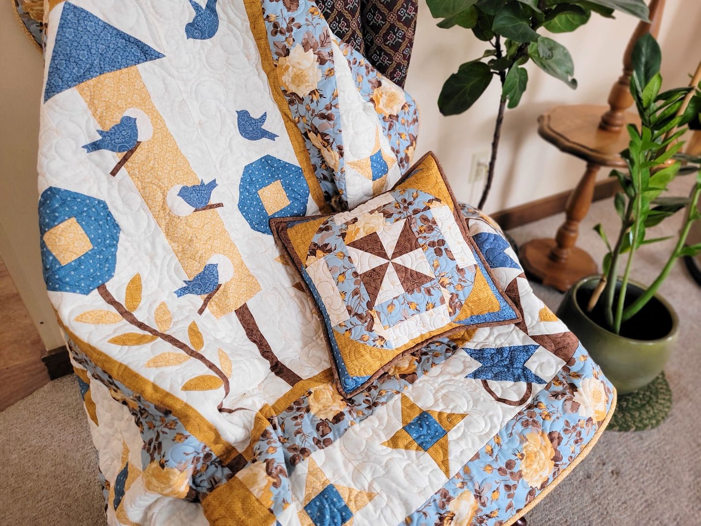 Quilt with matching pillow on a chair in a home setting.
