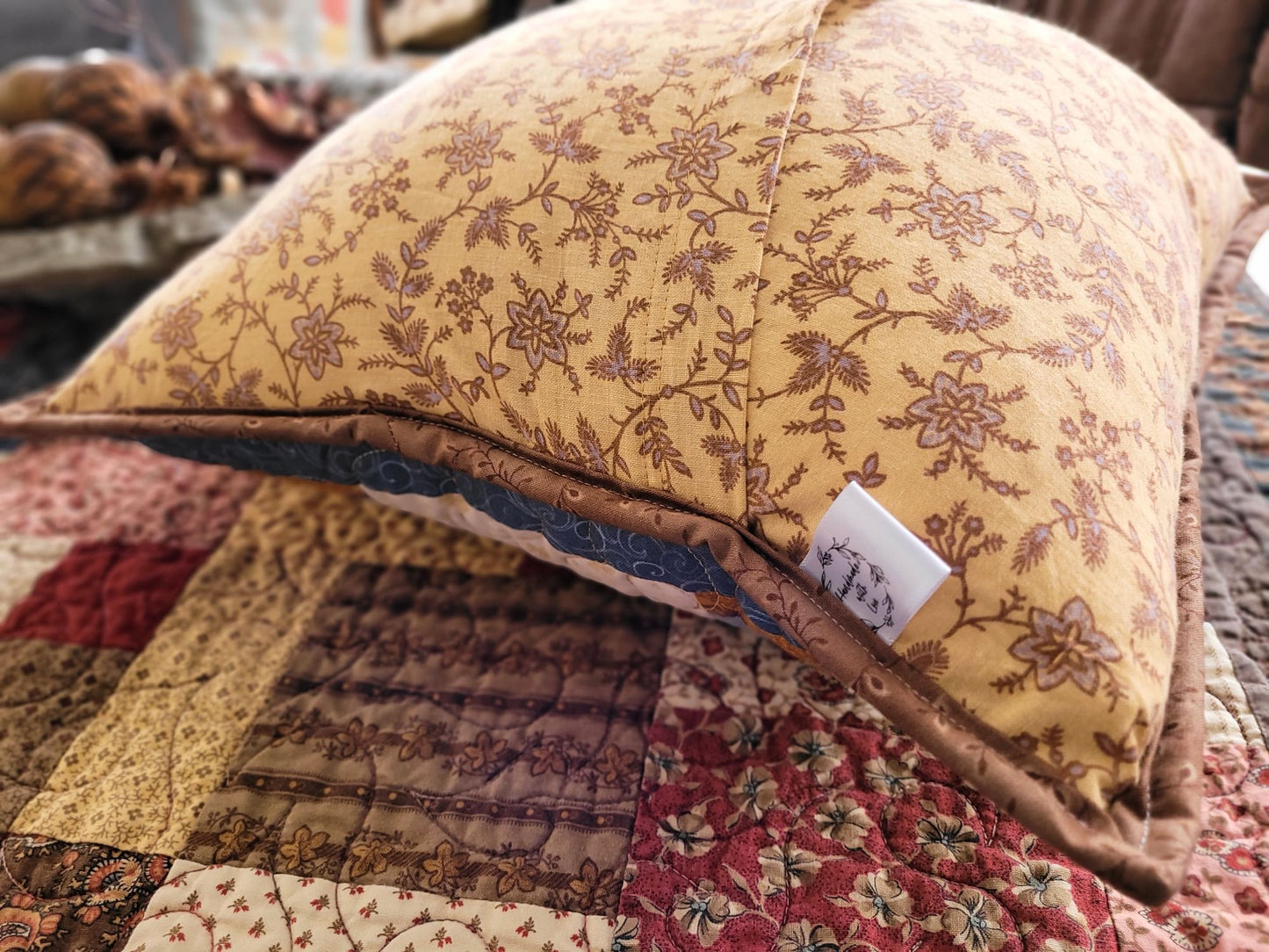 Showing the overlapping back of the quilted pillow and the 'Handmade with Love' label.