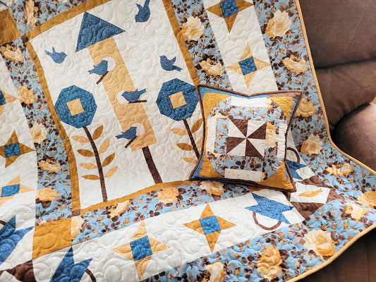Quilt with floral and bird patterns on a couch