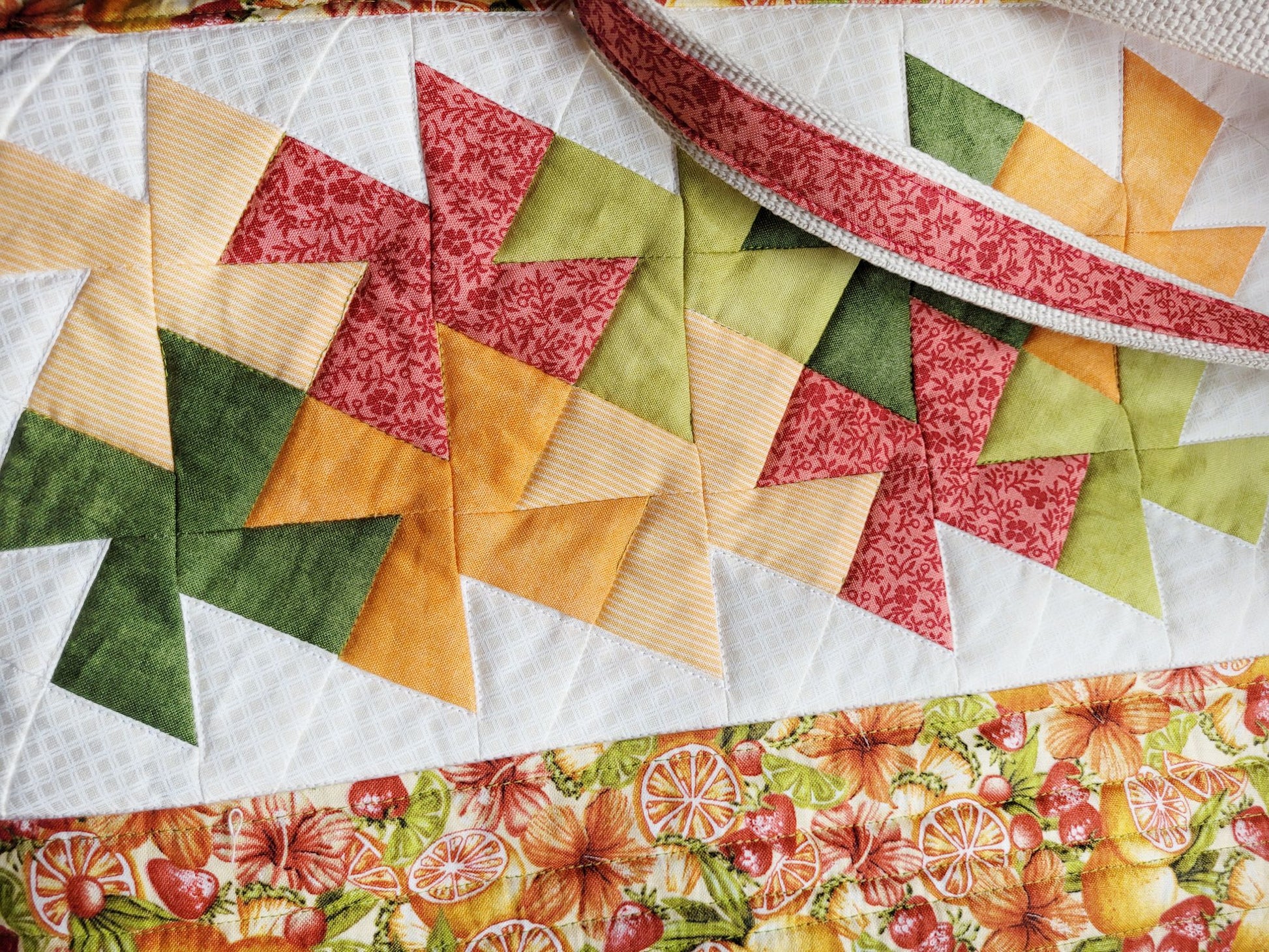 Close up of quilted tote bag with twister patchwork in colourful fabrics.