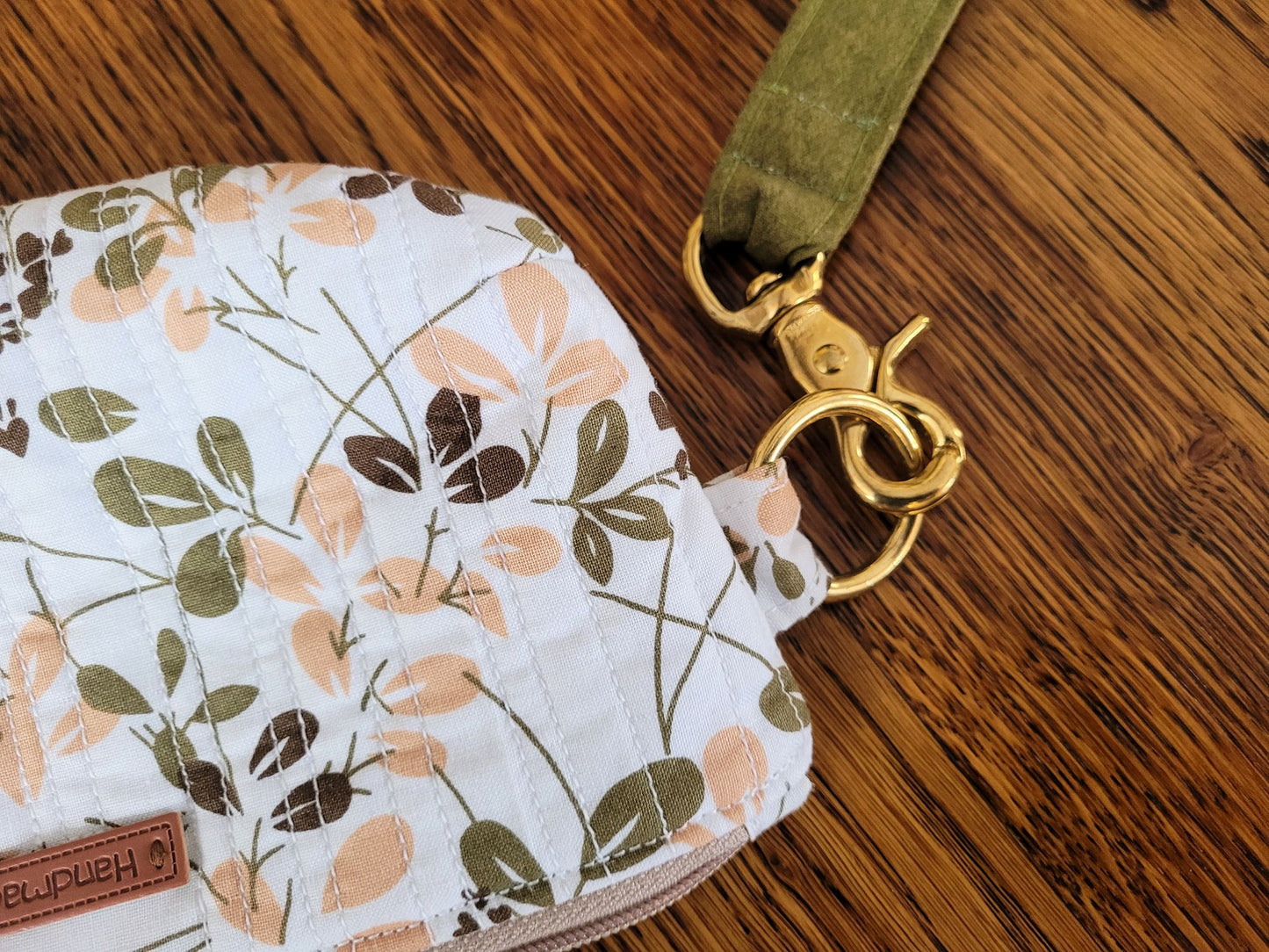 Showing close up of handle hardware and quilted fabric of the wrist pouch.