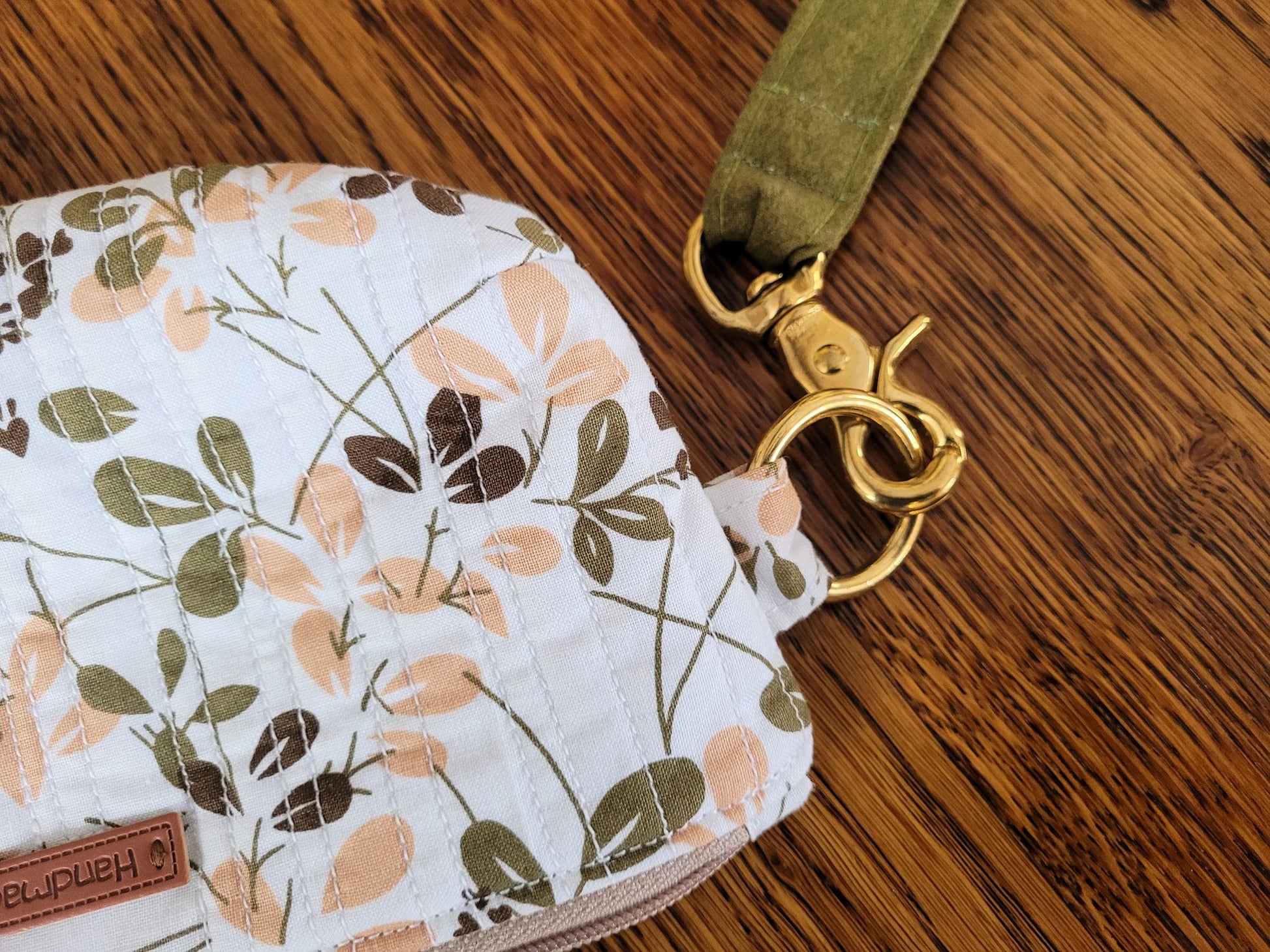 Showing close up of handle hardware and quilted fabric of the wrist pouch.