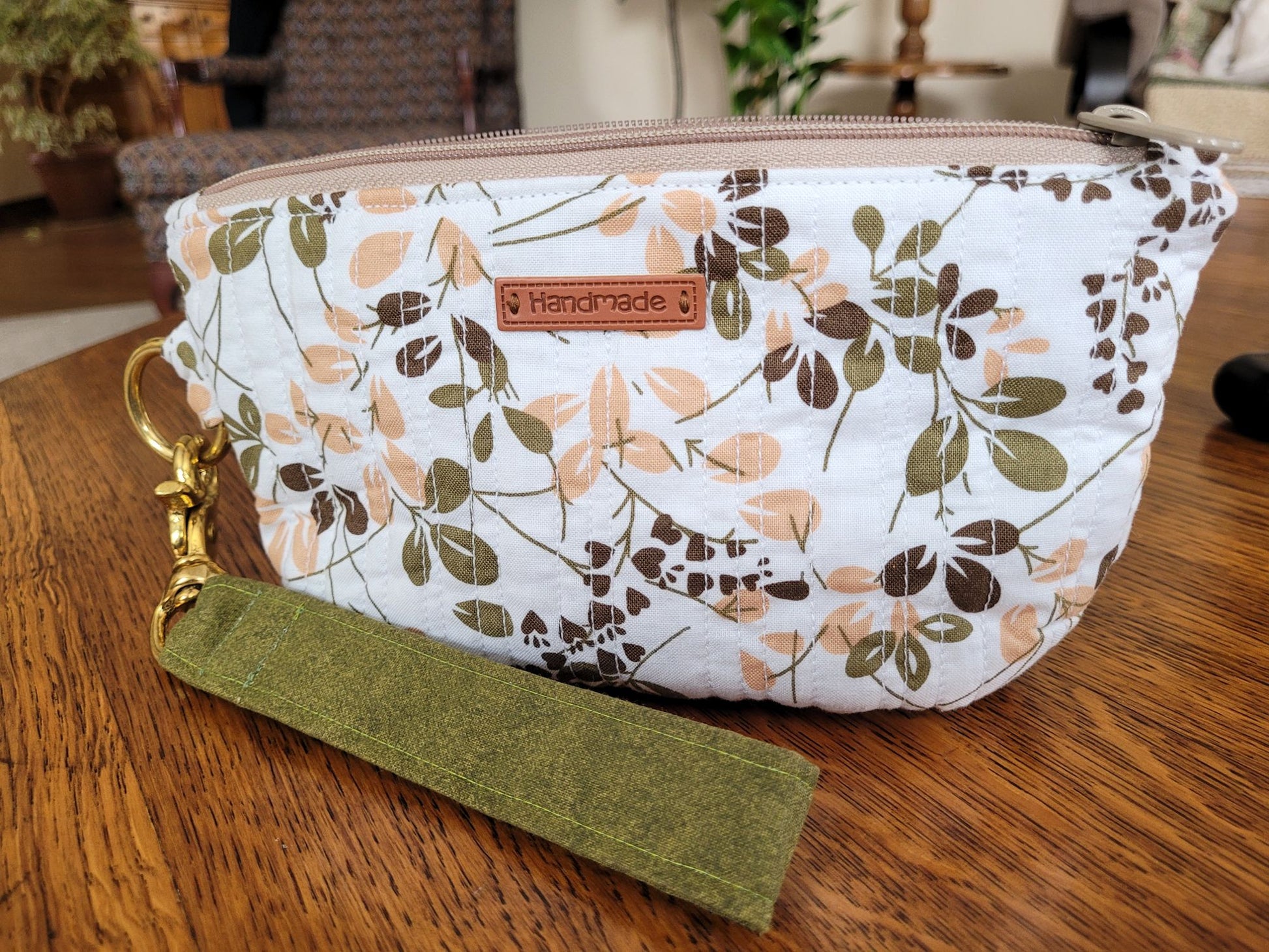 Close up of quilted zipper bag in green leafy fabric.