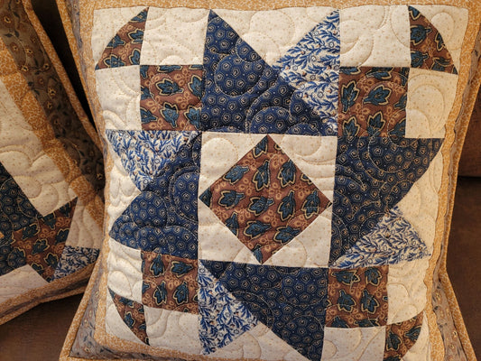 Friendship Star quilted pillow in blue and brown patchwork on Cream background. 